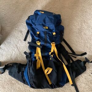 Navy blue, black, and gold vintage The North Face backpack for backpacking 65L